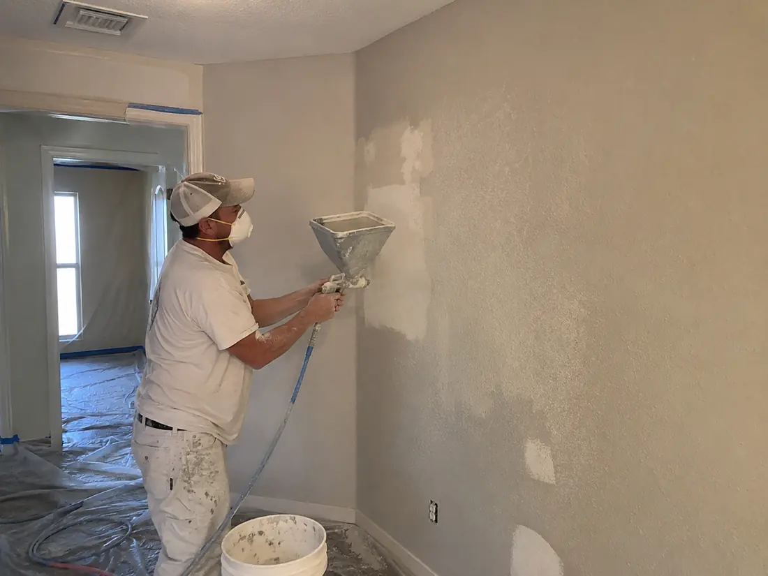 Spray texture being applied and matched to an existing wall